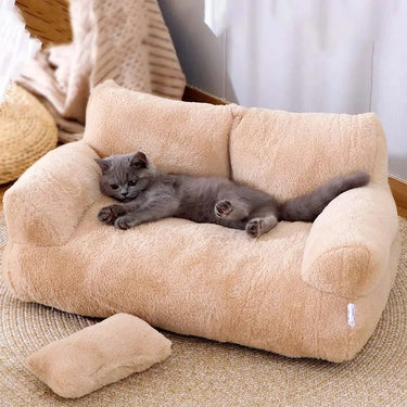 A gray cat lounges on KittyNook Cat Co.'s Luxury Lounge Pet Sofa Bed, nestled on a round rug with a matching cushion nearby.